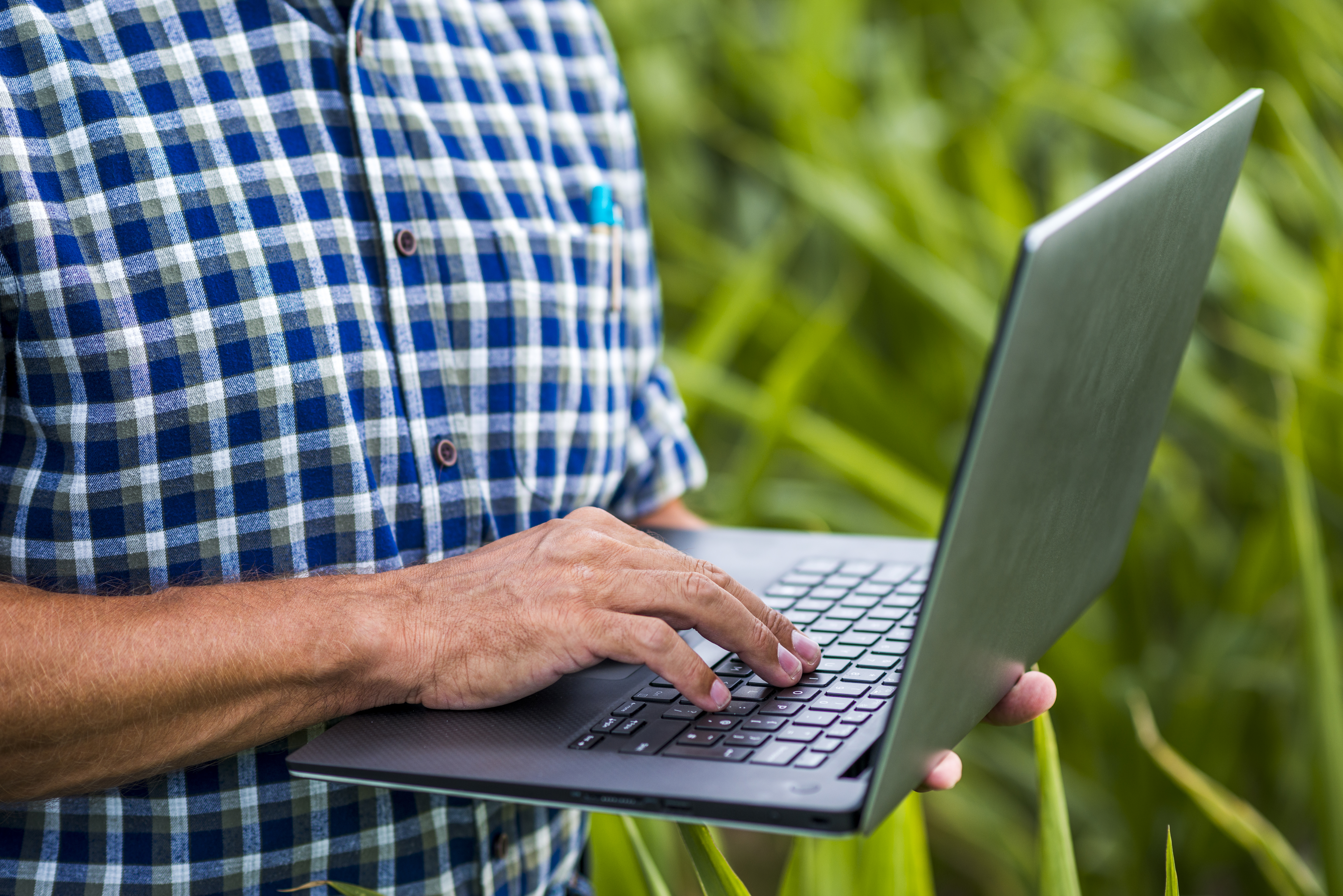 imagem de um homem ultilizando um computador no campo
